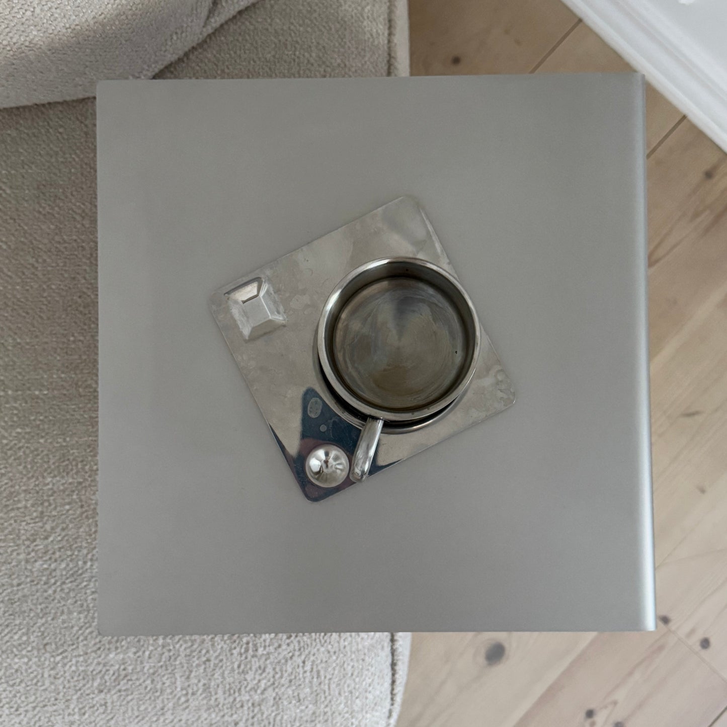 Top view of the Elegance Side Table beside an armchair with a coffee cup placed on top.